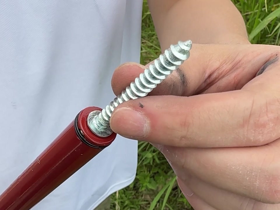 手指把鍍鋅藍波釘套進鑽兼鎖前端套管內的近距離特寫